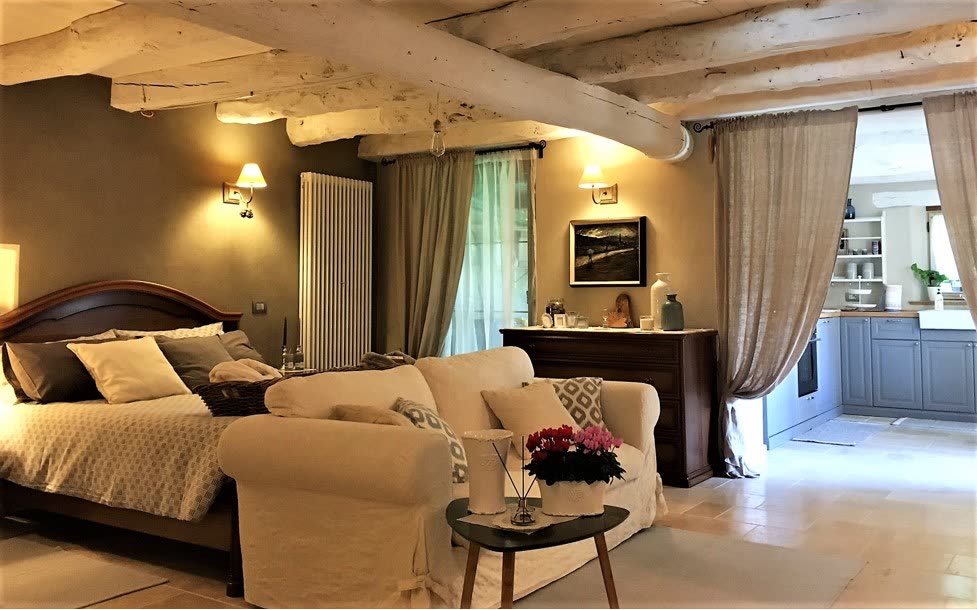 Ambiente open space con letto, divano e angolo cucina